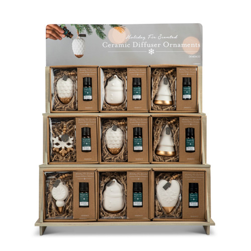 A three tier wood displayer holding nine packaged holiday ceramic diffuser ornaments.