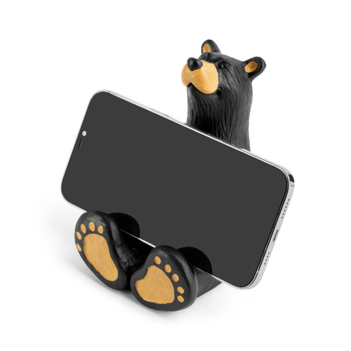 A sitting black bear figurine that can hold a cell phone or notepad, displayed angled to the left holding a cell phone.