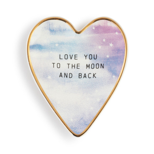 Heart shaped ceramic dish with a gold rim. It has a purple and blue celestial look and says "Love You To The Moon And Back".