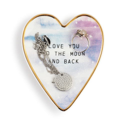 Heart shaped ceramic dish with a gold rim. It has a purple and blue celestial look and says "Love You To The Moon And Back", displayed with a ring and necklace inside.