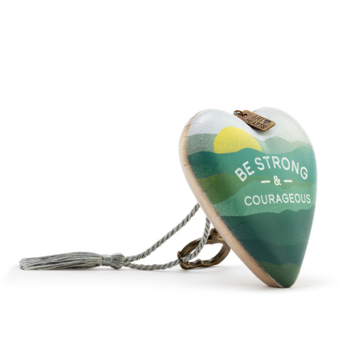 Heart shaped sculpture with a silver tassel and metal key attached. The heart has a green mountain scene and says "Be Strong & Courageous", displayed angled to the right.