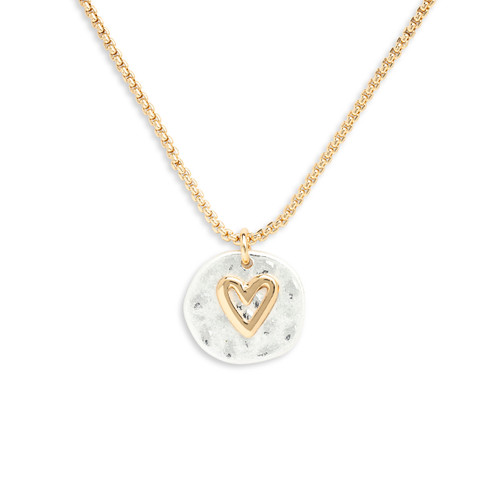 Detail view of the heart charm on a gold three strand necklace with champagne colored beads and a charm that is a mixed metal circle with a gold heart.