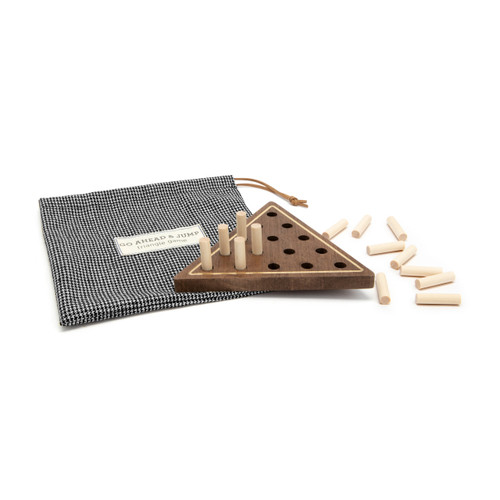 A wood triangle wood peg game in dark wood with a gold border, displayed with some of the pegs in the game and some out. The game comes in a black and white houndstooth fabric bag with a drawstring.
