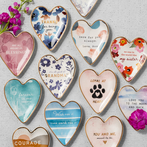 Twelve different Art Heart trinket dishes shaped like hearts with gold rims and a variety of sentiments and images.
