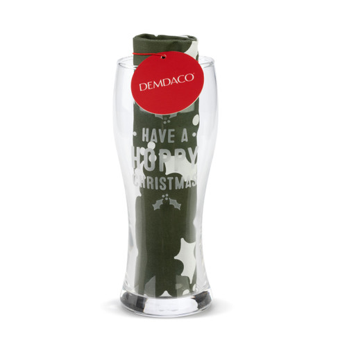 A clear pilsner glass that says "Have A Hoppy Christmas" with a dark green towel rolled and standing in the glass, displayed with a product information tag.