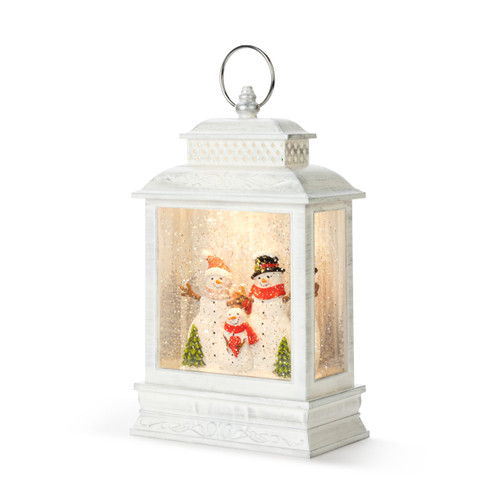 A white lit lantern with a snowman family in a snowy scene inside, displayed angled to the left.