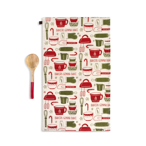 A tan kitchen towel with red and green tools for holiday baking next to a wood spoon with a red handle, shown with the towel laid out in its full size.