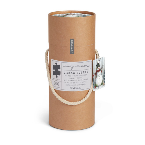 A circular cardboard tube packaging for a woodland snowman jigsaw puzzle. The container has a woven rope handle.