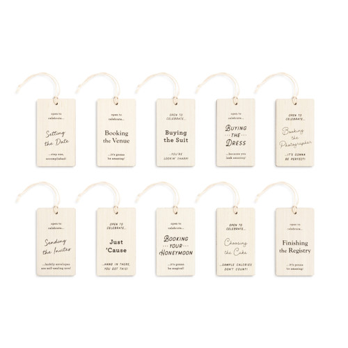 Set of 10 light wood bottle tags each marking a milestone in the planning of a wedding, laid out to see the different milestones in planning.