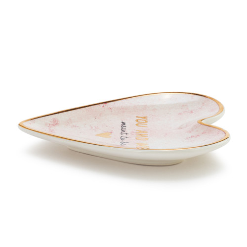 Side view of a heart shaped ceramic dish with a gold rim. The interior has a gold heart and says "You And Me, meant to be".