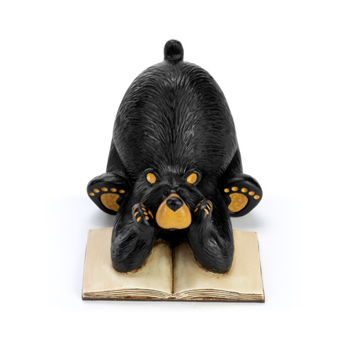 A sculpted black bear figurine bookend with a bear sitting and leaning on an open book.