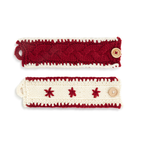 Two knit cup cozies one in white with red edging and the other in red with white edging. Each closes with a large wood button, displayed laid out flat.