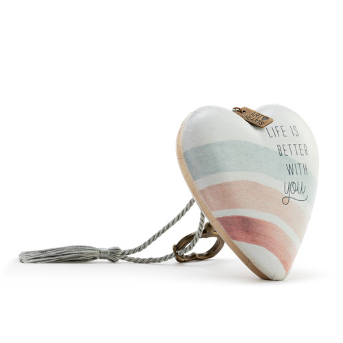 Heart shaped sculpture with a silver tassel and metal key attached. The heart has pastel rainbow stripes and says "Life is Better with You", displayed angled to the right.