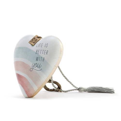 Heart shaped sculpture with a silver tassel and metal key attached. The heart has pastel rainbow stripes and says "Life is Better with You", displayed angled to the left.