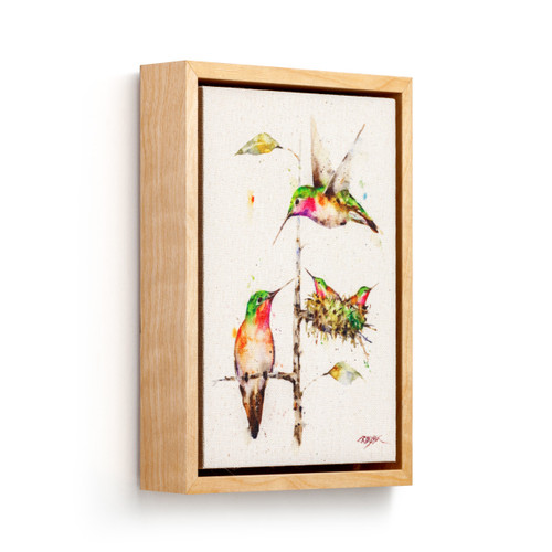 Light wood framed canvas wall art of a hummingbird family in watercolor, displayed angled to the right.