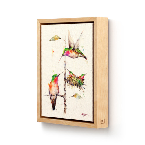 Light wood framed canvas wall art of a hummingbird family in watercolor, displayed angled to the left.