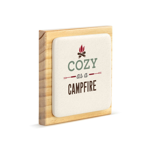 A light wood square plaque with a bone tile attached that says "Cozy As A Campfire" with an image of a campfire, displayed angled to the right.