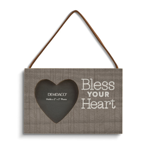 A rectangular wood hanging ornament with a 2 inch heart shaped opening for a photo next to the saying "Bless Your Heart" on a brown background.