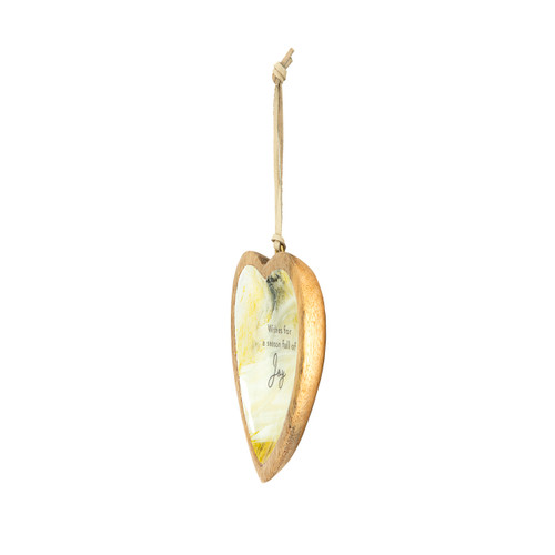A hanging heart shaped wood ornament with a yellow and cream artwork inside inspired by ArtLifting artist Grace Goad. The ornament says "Wishes for a season full of Joy", displayed angled to the left.