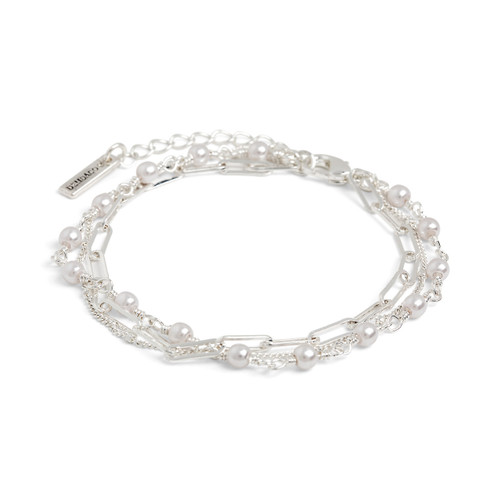 Close up angled view of a multi-strand silver chain adjustable bracelet with small pearls attached to one of the strands.