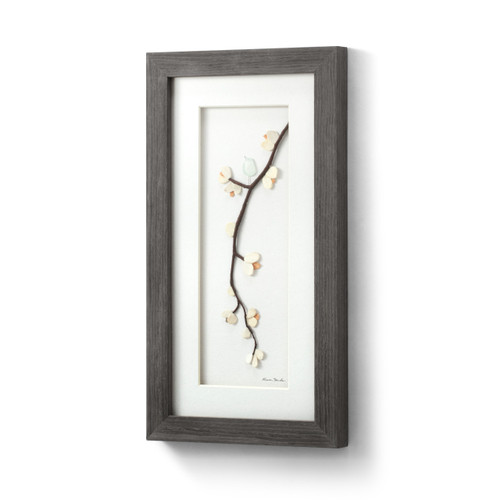 A gray wood framed image of a tree branch with a bird and flowers made of pebbles, displayed angled to the left.