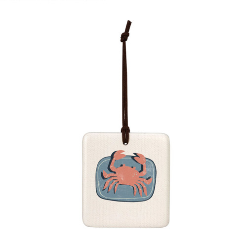 A square hanging tile ornament with a graphic image of a red crab on a blue background.