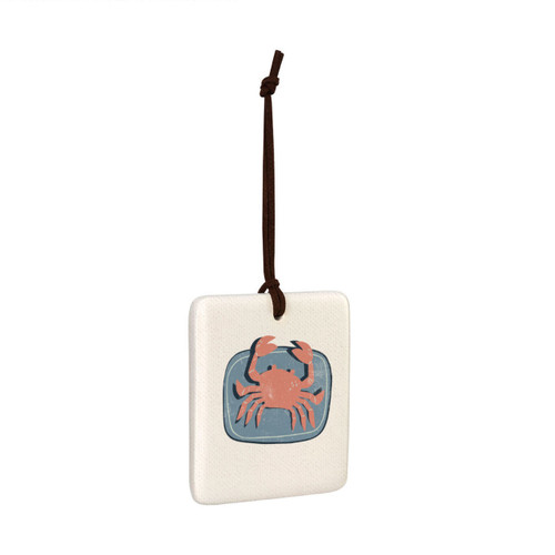 A square hanging tile ornament with a graphic image of a red crab on a blue background, displayed angled to the right.