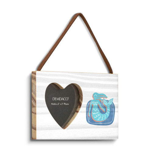 A rectangular hanging white wood frame ornament with a graphic image of a light blue mermaid on a blue background with a 2x2 heart shaped opening for a photo, displayed angled to the right.