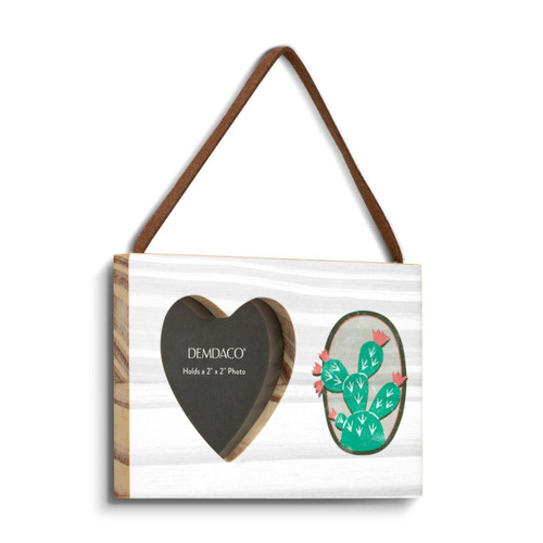 A rectangular hanging white wood frame ornament with a graphic image of a green cactus with pink flowers and a 2x2 heart shaped opening for a photo, displayed angled to the right.
