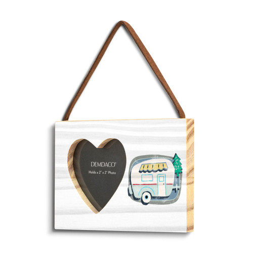 A rectangular hanging white wood frame ornament with a graphic image of a white camper with a 2x2 heart shaped opening for a photo, displayed angled to the left.