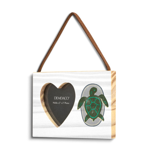 A rectangular hanging white wood frame ornament with a graphic image of a green turtle on a gray background with a 2x2 heart shaped opening for a photo, displayed angled to the left.