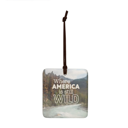 A square tile hanging ornament with a mountain stream and says "Where America is still Wild".