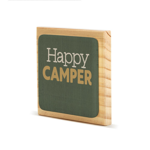 A square wood plaque with a dark green tile that says "Happy Camper", displayed angled to the left.