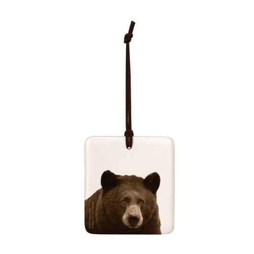 A white square tile hanging ornament with the image of a bear.