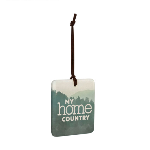 A square tile hanging ornament with a green mountain scene that says "My home country", displayed angled to the right.
