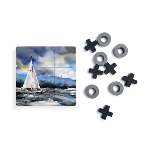 A square wood tic tac toe board with a watercolor image of a sailboat at sea, next to a set of X's and O's in gray and black.
