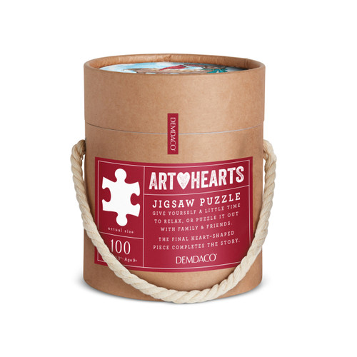 The cardboard tube packaging and rope handle for a heart shaped 100 piece puzzle of a deer in a scarf with a red bird on his back that says "deer Friends".