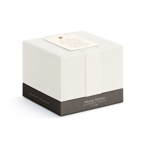 A small white winter wishes scented glass candle, displayed in its white packaging box with a cream ribbon and inspirational message tag.