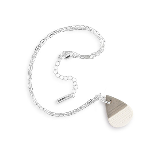 An adjustable silver chain necklace with a teardrop shaped gray and white diffuser charm, displayed laid out on a white background.