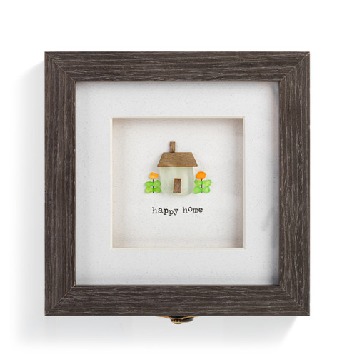 Top down view showing the artwork on a square gray wood keepsake box with a metal clasp. The top has pebble art of a house and says "happy home".
