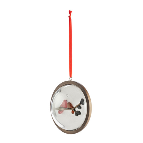 A hanging glass dome ornament on a wood base. The inside has a pebble image of two redbirds on a branch, displayed angled to the left.