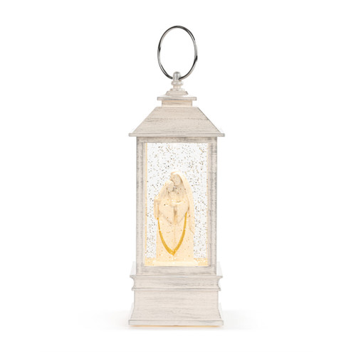 A lit white lantern with the holy family inside.