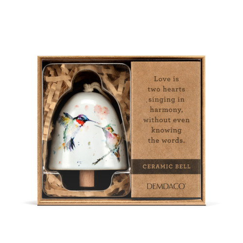 A white mini ceramic bell with a wood clapper. The bell has a watercolor image of hummingbirds on it, displayed in a brown packaging box.