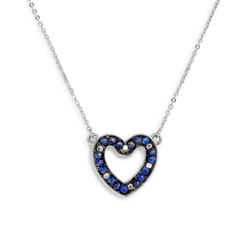 Detail view of the charm on a silver chain necklace with a heart shaped charm filled with small blue stones.