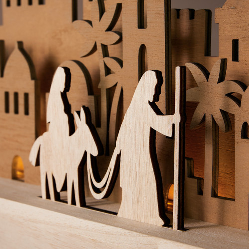 Detail view of a wood mantlescape which shows a silhouette layered view of Mary and Joseph traveling to Bethlehem.