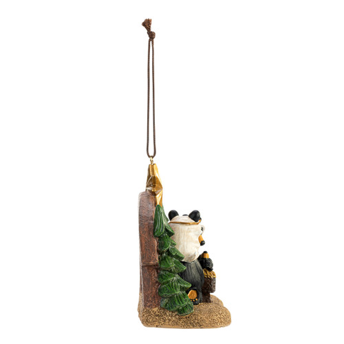 Right profile view of a hanging Christmas ornament of a nativity scene with black bears as the figures.