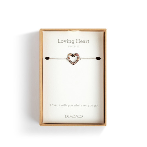 An adjustable silver chain bracelet with a heart shaped charm filled with small pink stones, displayed in a packaging box.