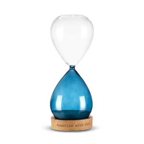 A glass sand timer with blue glass on the bottom half sitting in a wood base that reads "downtime with dad".