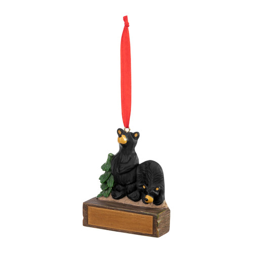 An ornament of two black bears on a rock next to an evergreen tree, hanging from a red ribbon. There is a spot in front for customization, displayed angled to the left.