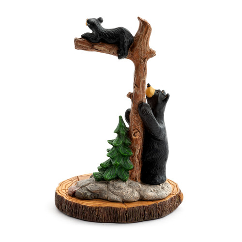 Back view of a figurine of an adult black bear standing at the base of a tree with a small bear up on a branch.